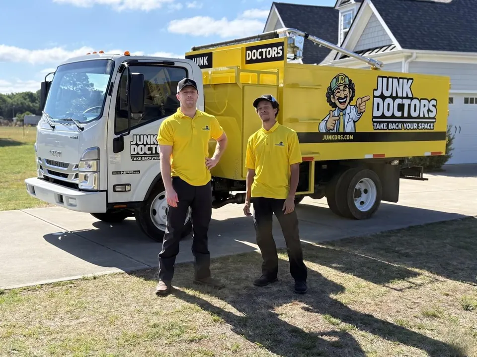 Two Junk Doctors crew members in front of a Junk Doctors truck