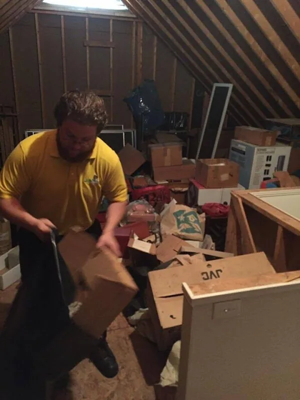 A Junk Doctors crew member clearing boxes out of an attic