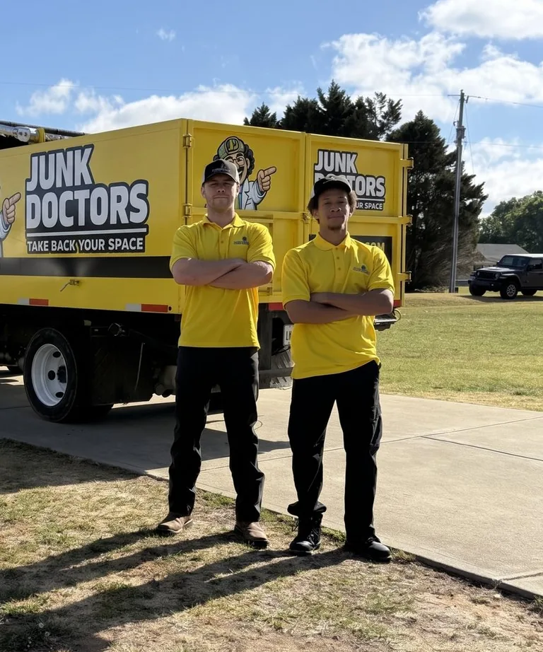Two Junk Doctors crew members in front of a Junk Doctors truck