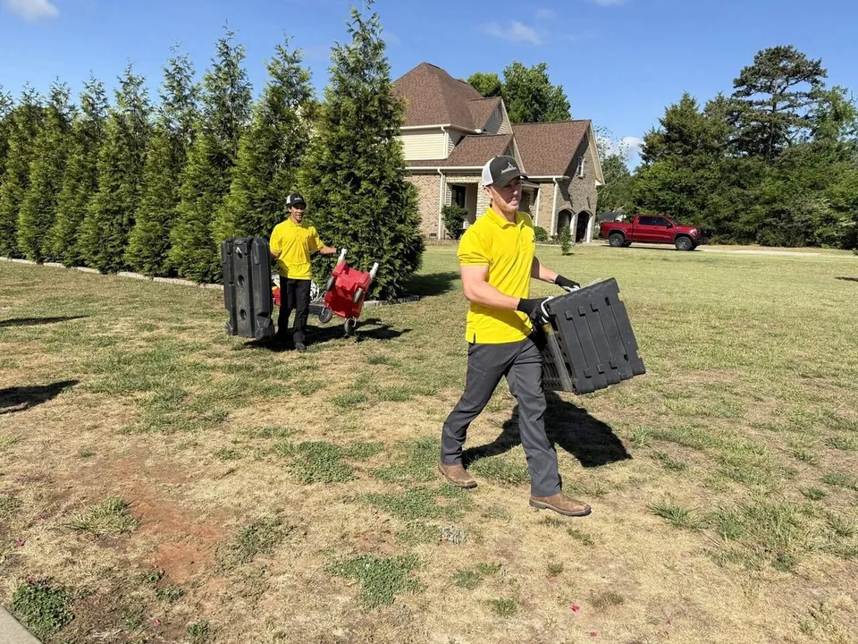 Junk Doctors crew members hauling yard items to the truck